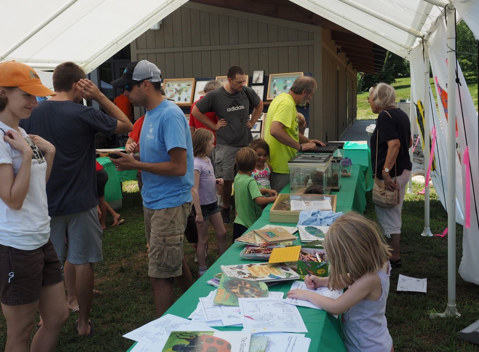 Picture of people gathered around display tables at event