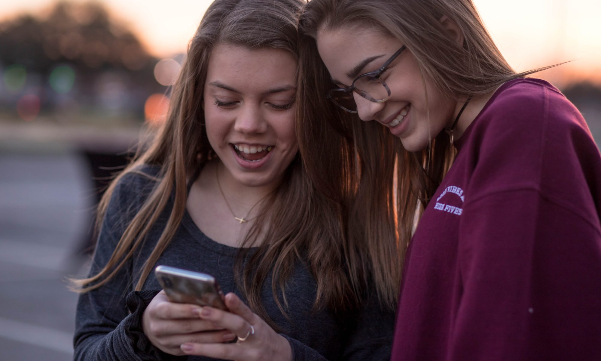 Picture of two teenage girls looking at a cell phone