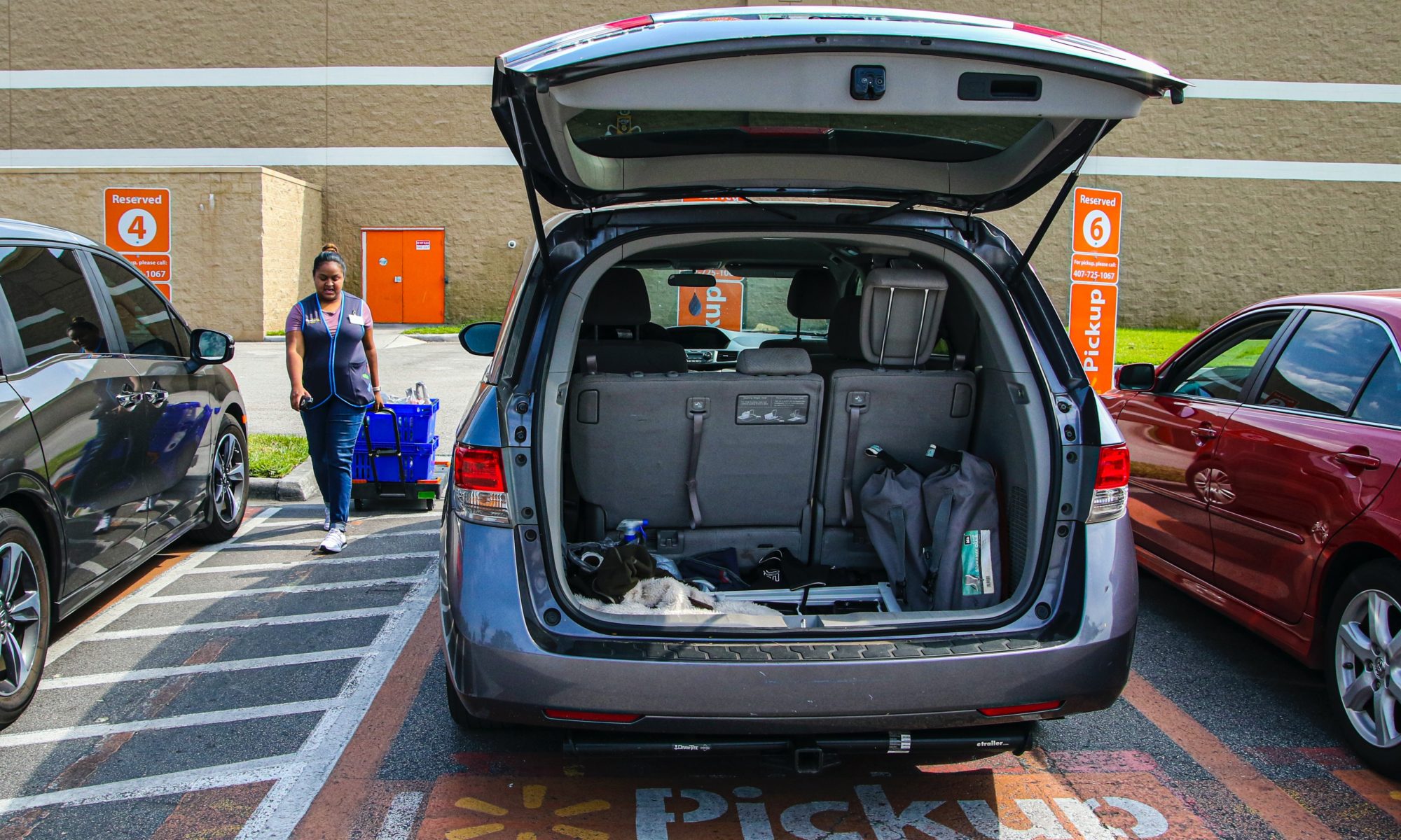 Picture of Walmart employee delivering groceries to a parked van