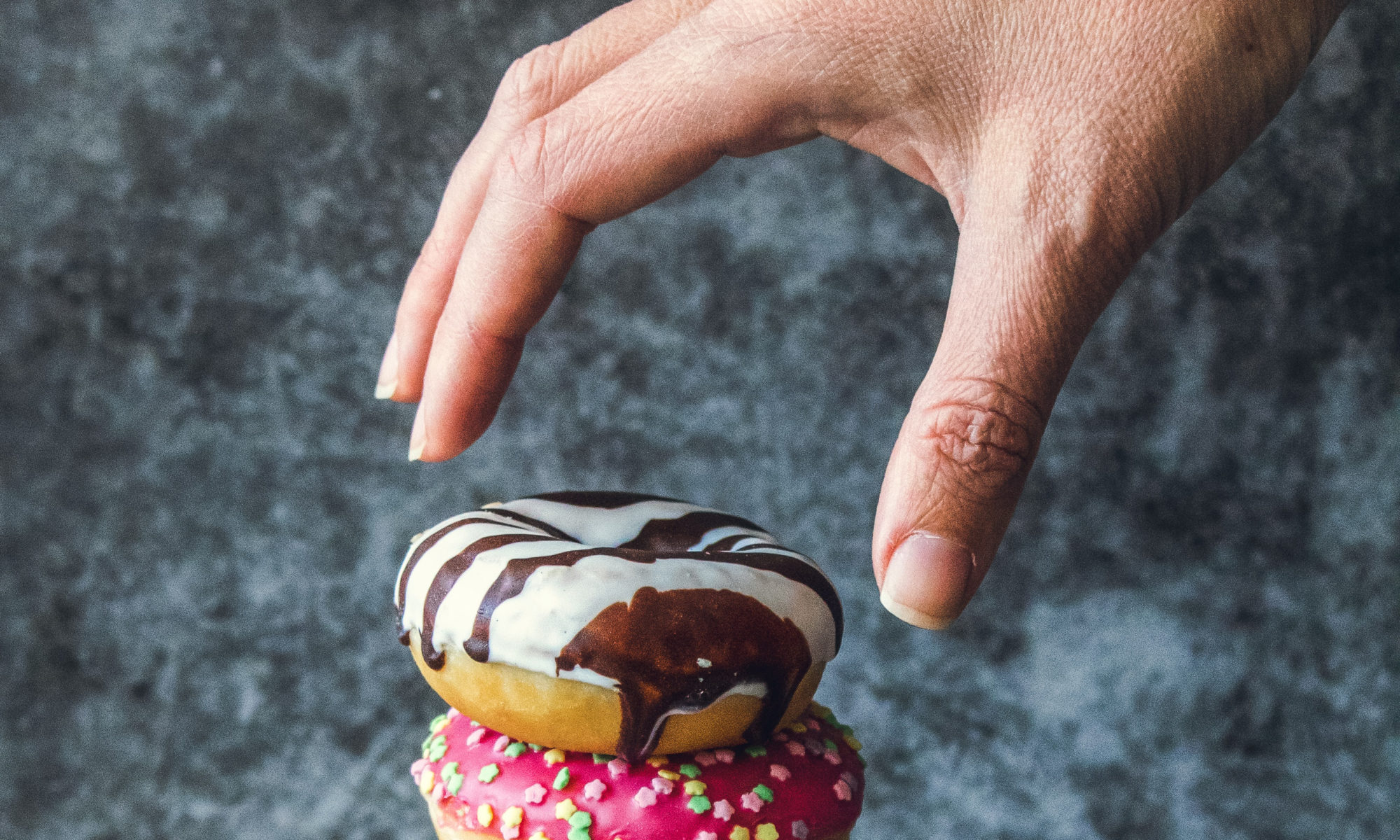 Picture of someone reaching for donut