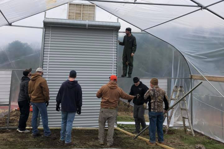 Picture of several men installing a high tunnel greenhouse
