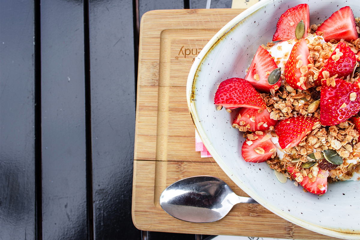 Picture of a breakfast bowl with grains, nuts and strawberries