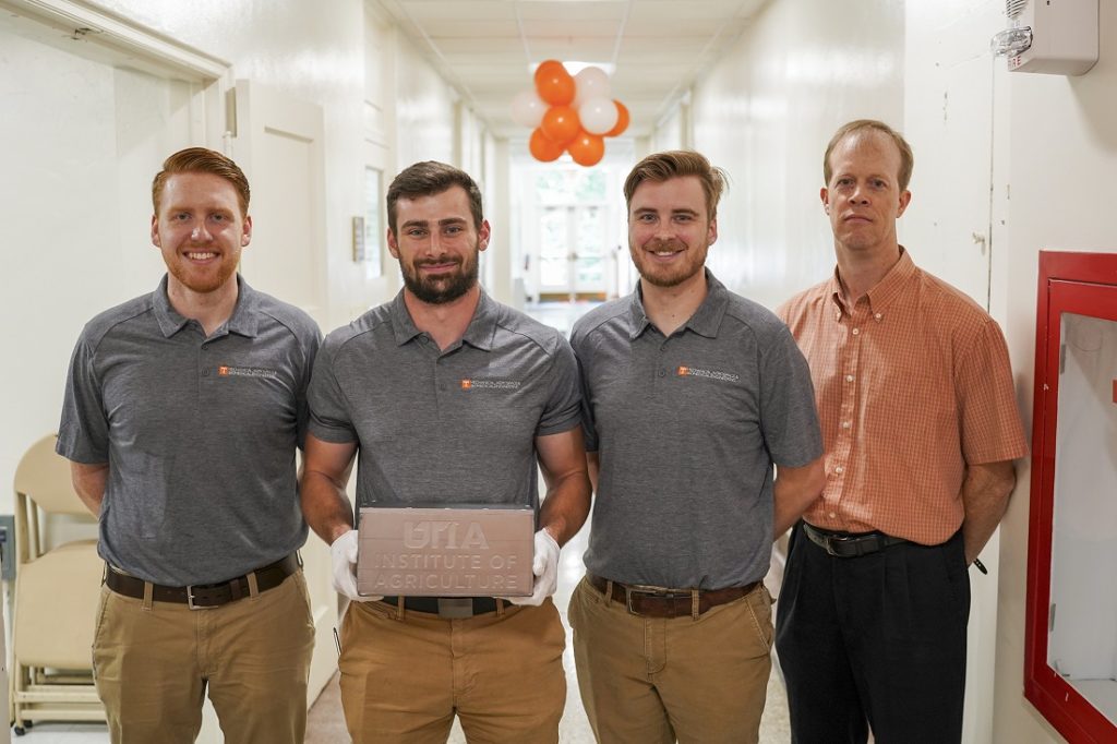 Greg Corson, Ross Zameroski, and Josh Penney with associate professor Bradley Jared. Ross Zameroski is holding the new UTIA Morgan Hall time capsule.