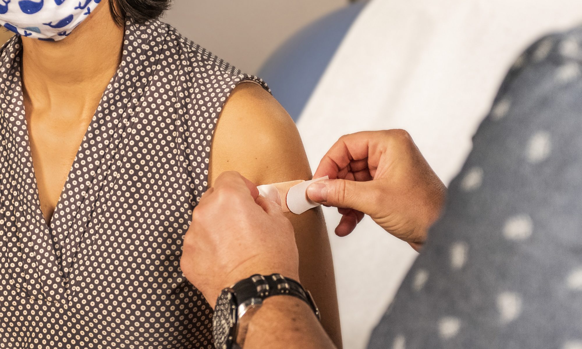 Picture of someone applying a bandaid to a person's arm