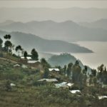 A skyline of Northwestern Rwanda is foggy and dotted with the tin roofs of houses.