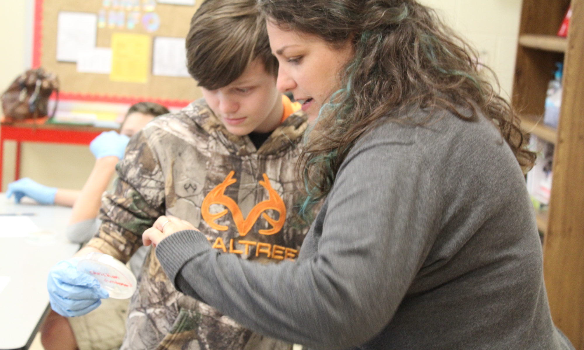 An ALEC faculty member working with a child in a classroom.