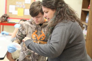 An ALEC faculty member working with a child in a classroom.