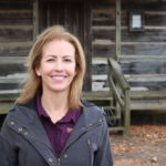 LesLee Smelser stands in front of cabin at Milan AgResearch and Education Center
