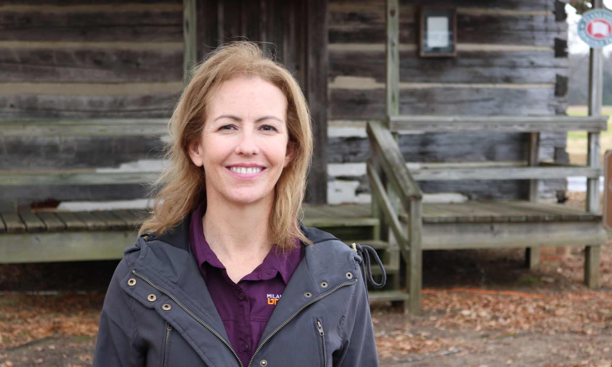 LesLee Smelser stands in front of cabin at Milan AgResearch and Education Center