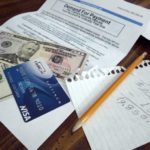 Picture of cash, credit card, and various papers where a family has planned for a budget