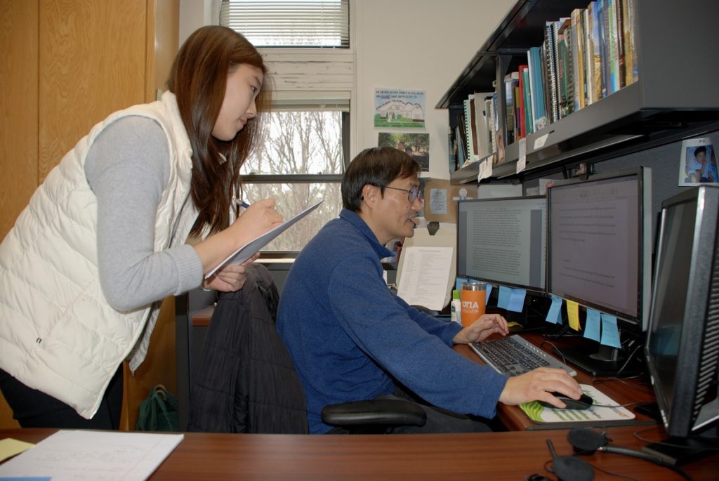 student and researcher gathering data at computer
