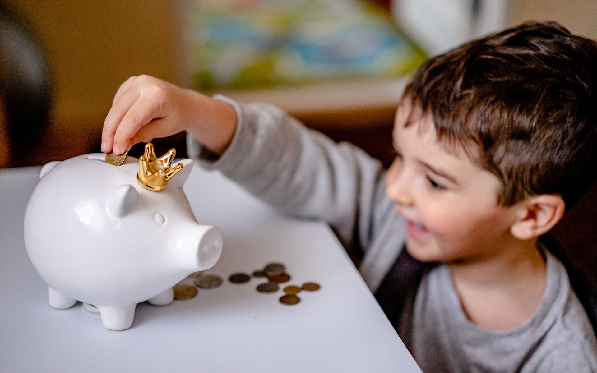 Child putting coin in piggy bank