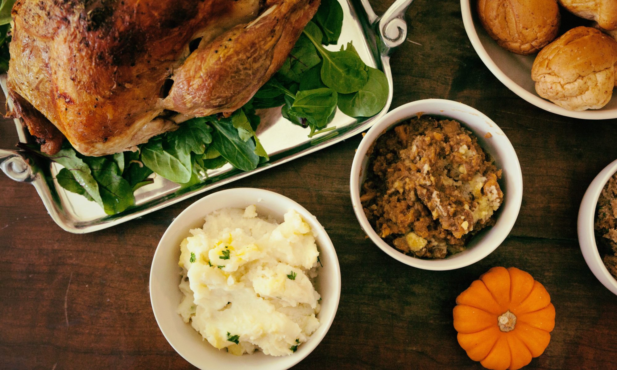 Holiday dishes filled with turkey, stuffing and mashed potatoes on a table