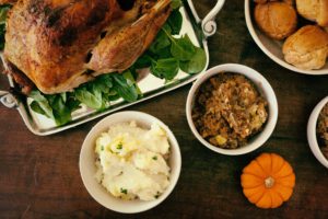 Holiday dishes filled with turkey, stuffing and mashed potatoes on a table