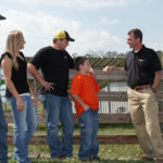 UT Extension agent talkign with family of four on farm