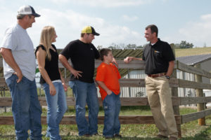 UT Extension agent talkign with family of four on farm