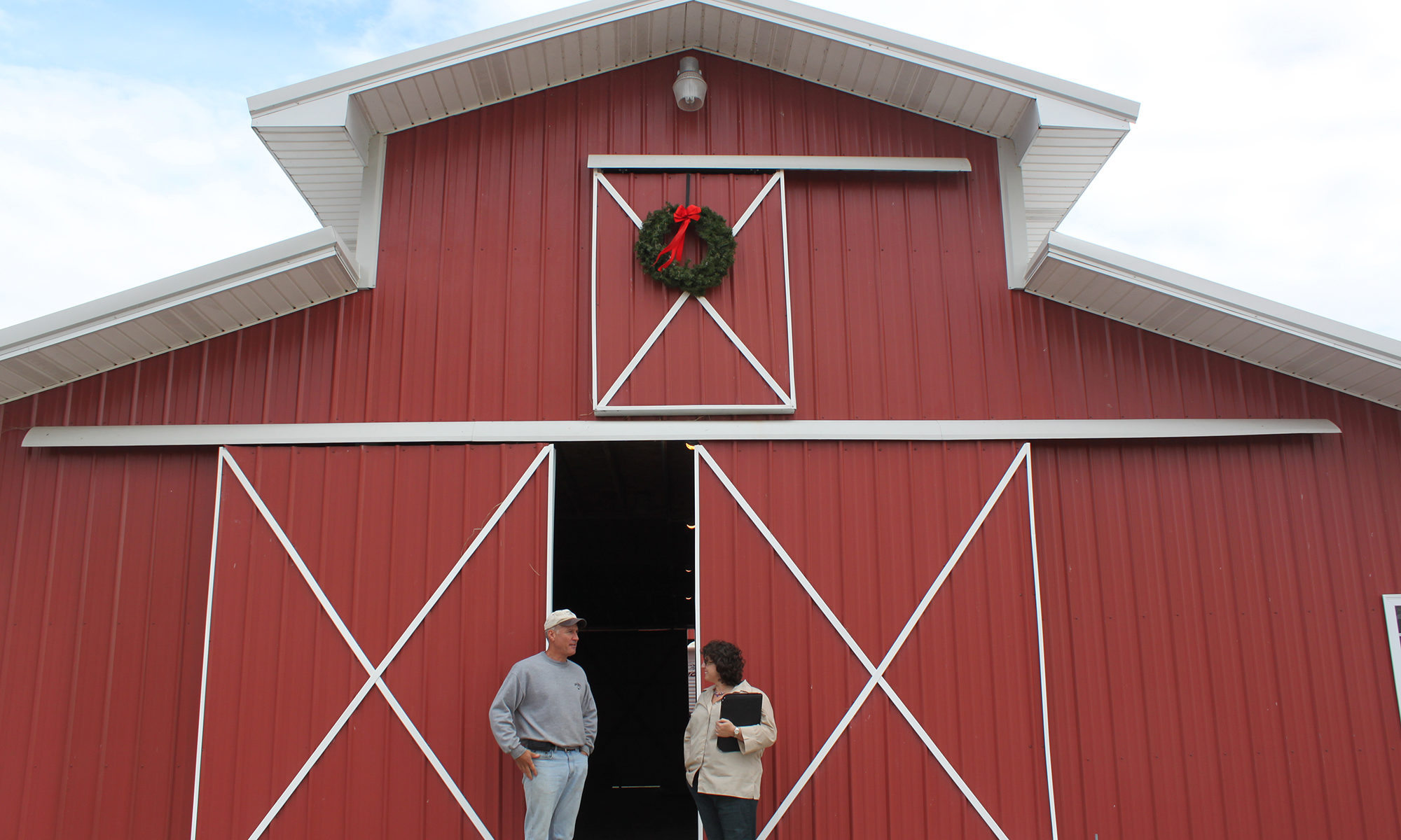 CPA specialist speaks with producer in front of red barn