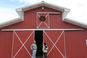 CPA specialist speaks with producer in front of red barn
