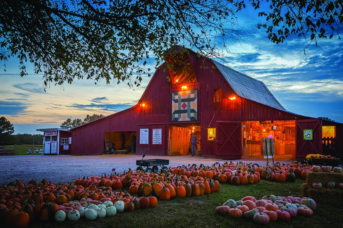 red barn in front of sunset sky