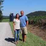 Kyle and Miranda Owen stand in a gravel lane on their farm