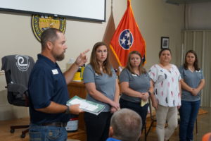 four people stand in front of a Tennessee flag. Left to right are Jake Mallard, Carrie Joyner, Deanna Poole, Misty Brasher and Tori Griffin.