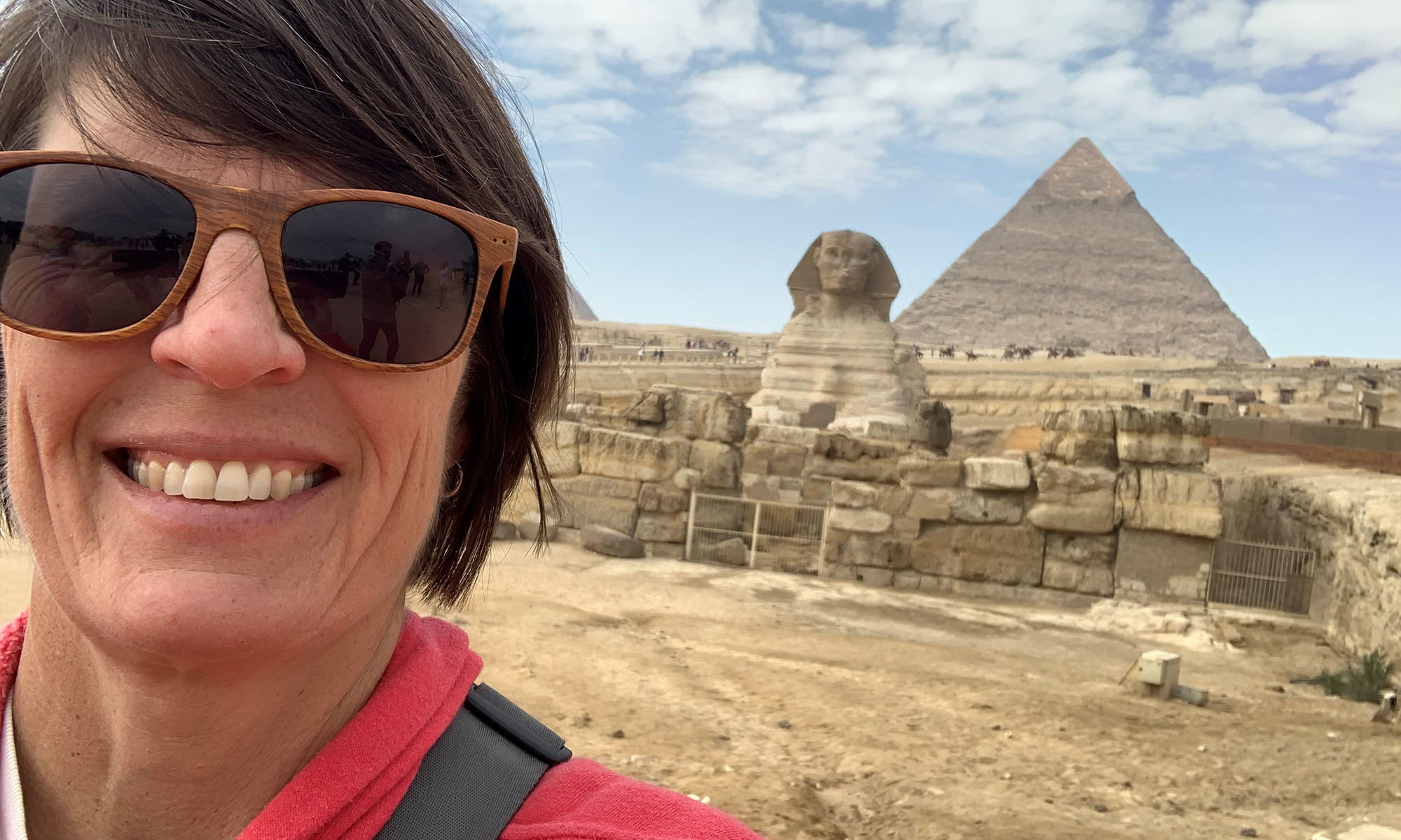 Marcy Souza in Egypt poses in front of the sphynx and a pyramid.