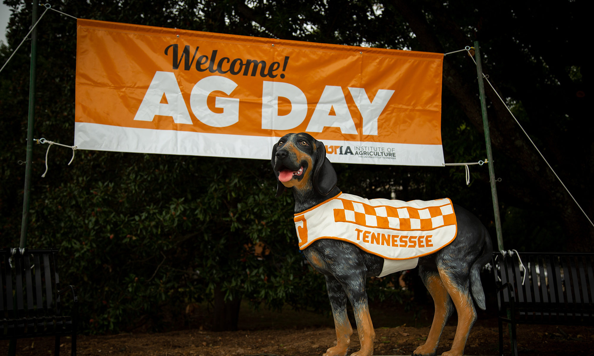 smokey the dog statue in front of an orange and white banner that reads "Welcome! Ag Day"