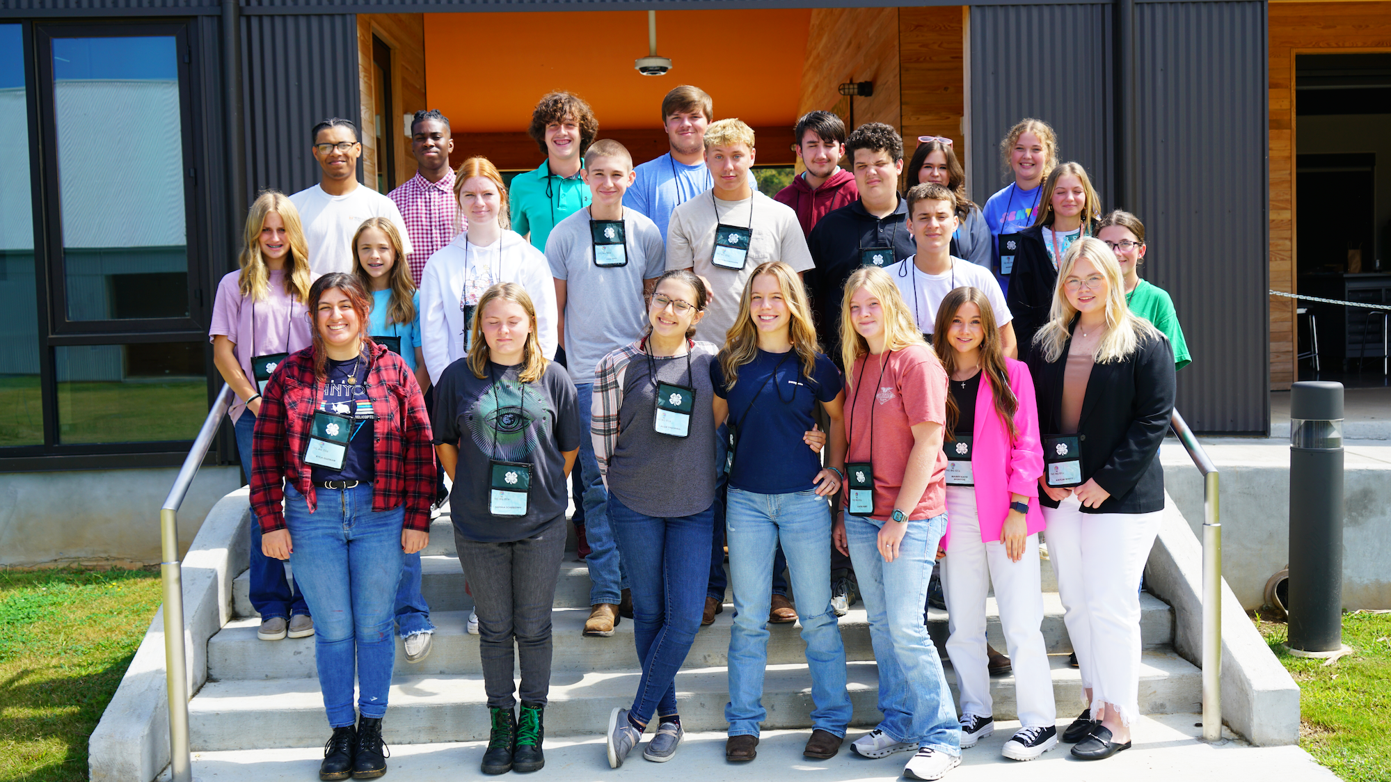 Students pose for a photo on the steps of Lone Oaks Farm's 4-H and Youth Development Center during the BIG Idea Youth Entrepreneurship Academy.