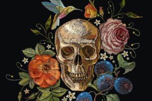Embriodered skull surrounded by flowers and a hummingbird
