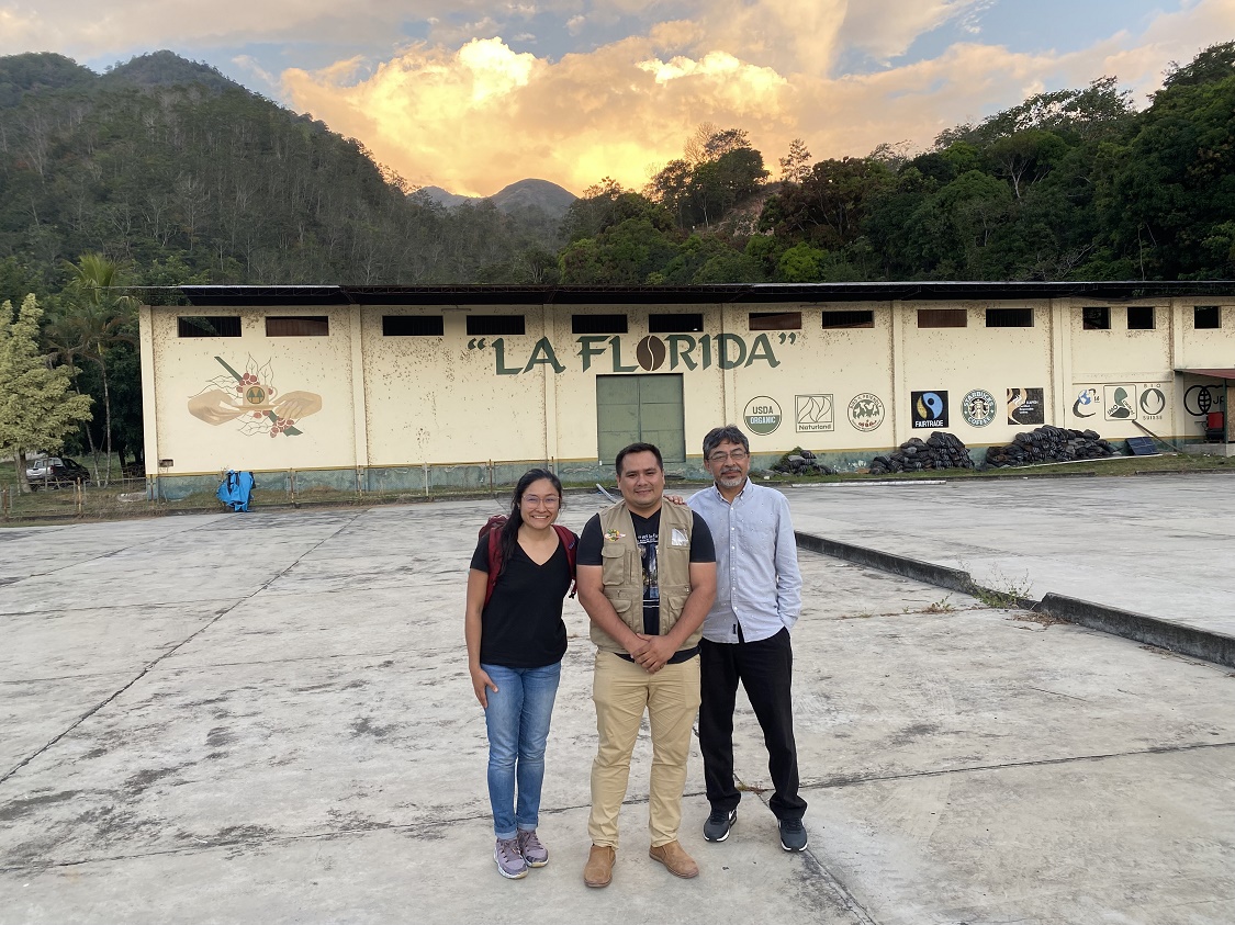 María Franco Escobar, Edwin Villa, and Carlos Trejo-Pech stand in front of a sunset and a wall that has a mural reading "La Florida"