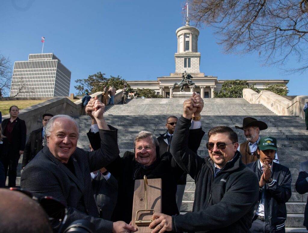 Tennessee senators pose at the steps of the capitol while holding their award for winning the straw bale throwing contest