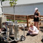 Darlene Player and Bailey Millsaps studying a Pot-in-Pot Extraction Robot prototype