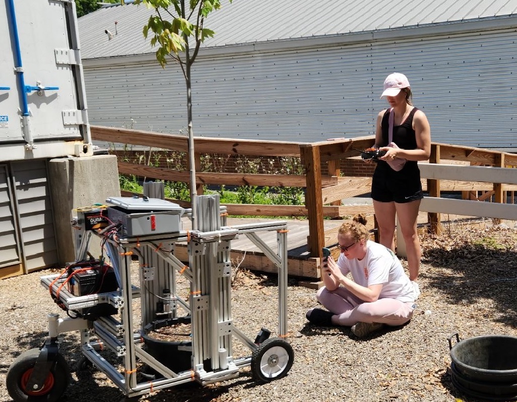 Darlene Player and Bailey Millsaps studying a Pot-in-Pot Extraction Robot prototype