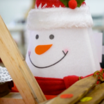 A felt snowman on a craft table