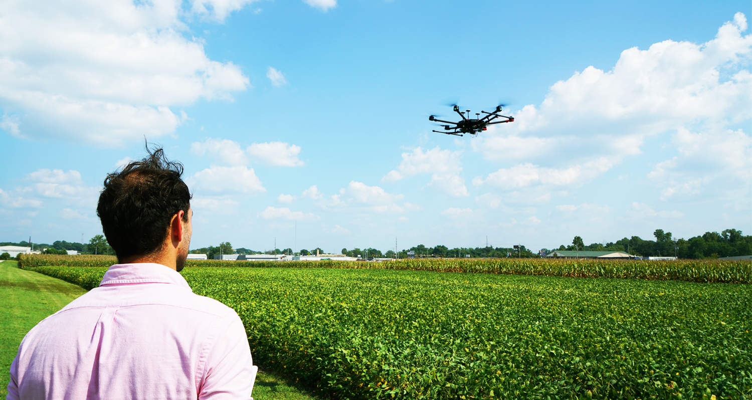 a man flying a drone over a field