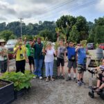 Sow 2 Grow students show off the fruits of their labors after harvesting an array of vegetables at the UT Gardens, Knoxville.