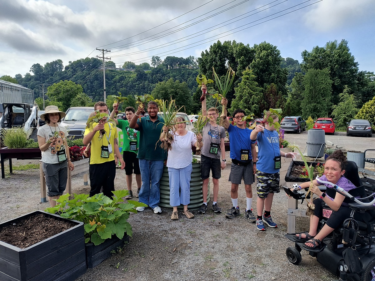 Sow 2 Grow students show off the fruits of their labors after harvesting an array of vegetables at the UT Gardens, Knoxville.