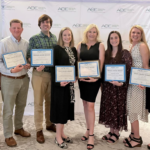 Marketing and communications professionals holding their award certificates