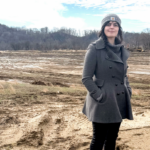 Emine Fidan standing in a field that was impacted by floods