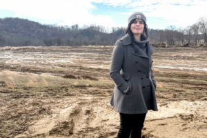 Emine Fidan standing in a field that was impacted by floods
