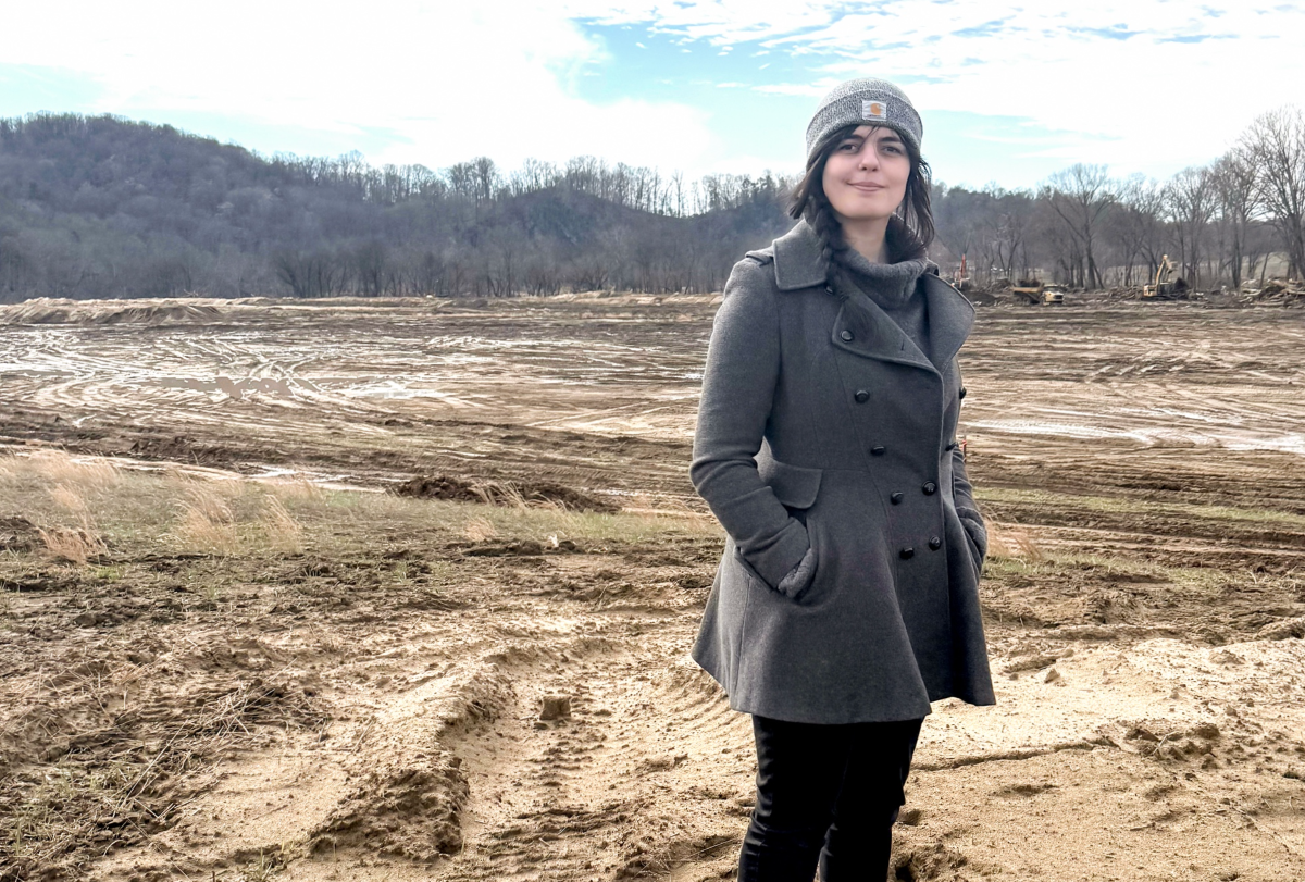 Emine Fidan standing in a field that was impacted by floods