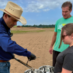 farmer Will Runion takes soil samples from one of his reclaimed flooded fields with Bruno Pedreira and Ali Bledsoe