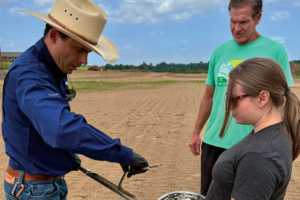 farmer Will Runion takes soil samples from one of his reclaimed flooded fields with Bruno Pedreira and Ali Bledsoe