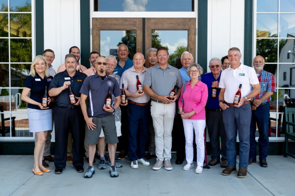 Representatives from UTIA and Apple Barn posing with bottles of Sweet Traditions