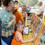 adults and a child looking at insect displays