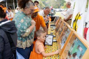 adults and a child looking at insect displays