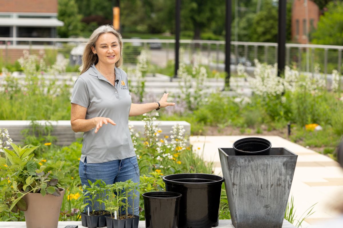 Natalie Bumgarner on a rooftop garden demonstrating how to care for container plants