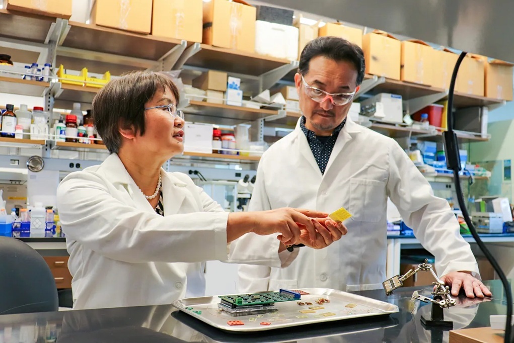 Jayne Wu, left, and Shigetoshi Eda work on a biosensor device that detects PTSD.