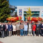 a group of people gathered in front of a new fleet of kayaks at Tennessee RiverLine’s Anchored in Alabama event