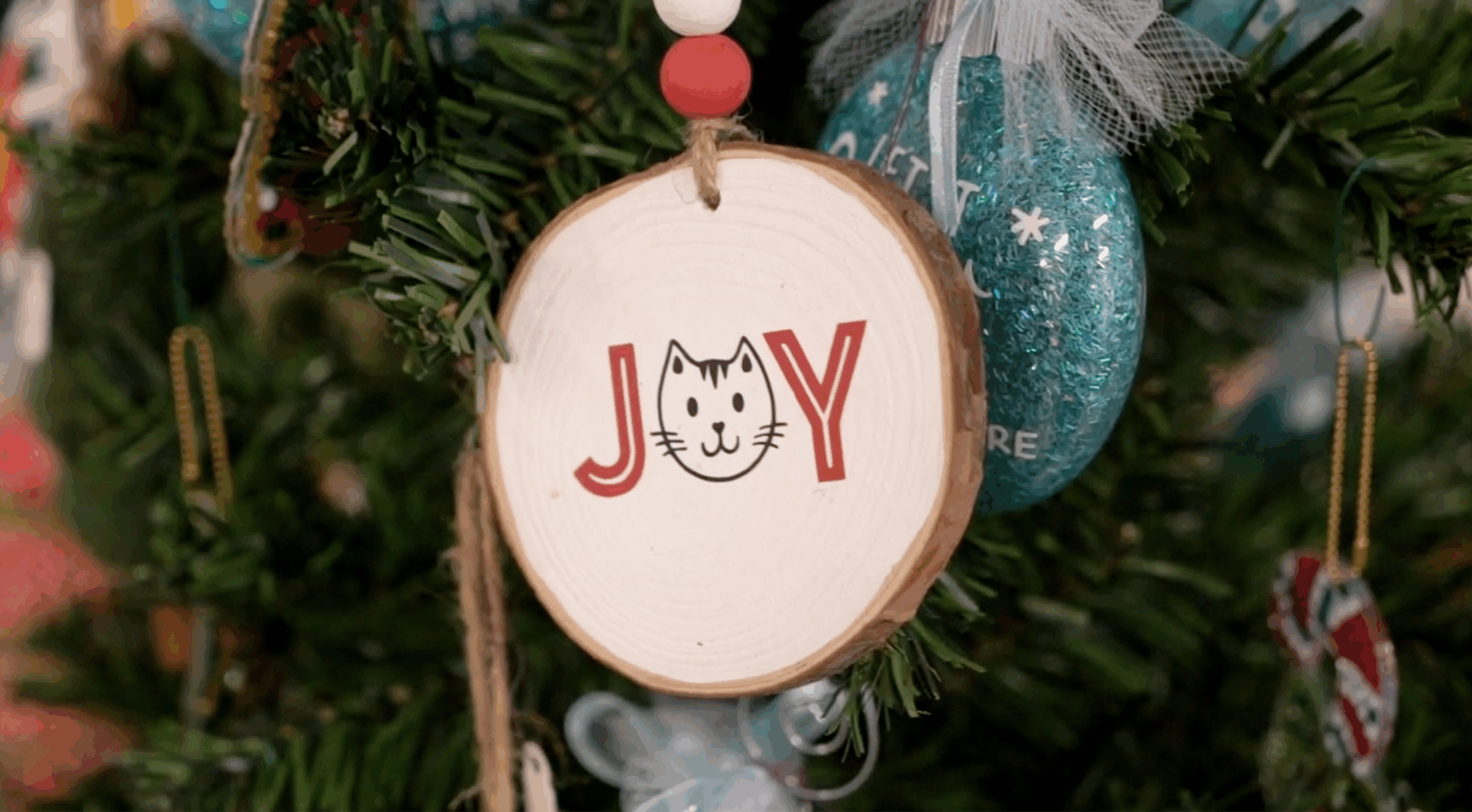 A round wooden Christmas ornament with the word 